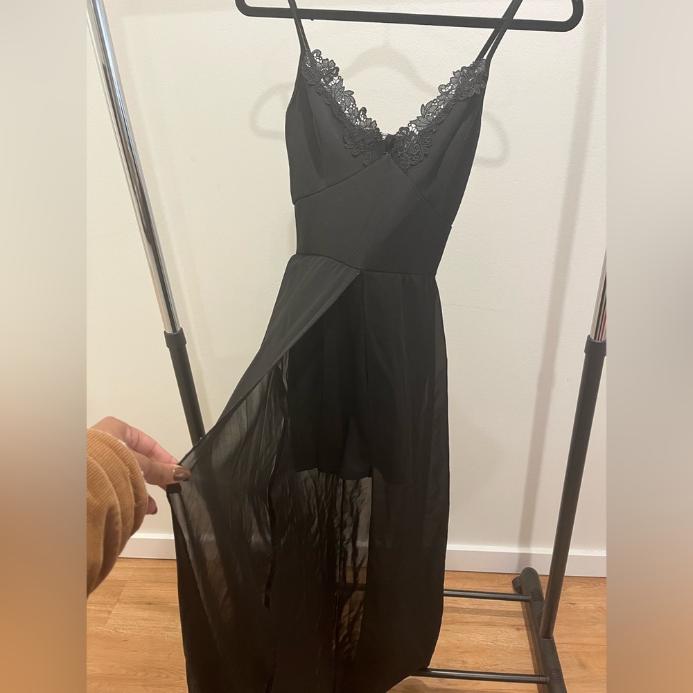 Black dress with long drape around waist.